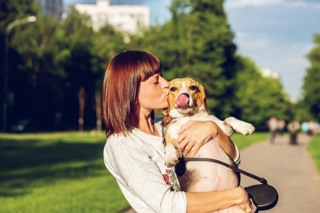 Real photo of a woman hugging her dog outdoors in a park